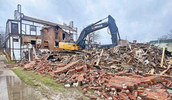 Norfolk Tavern building from the back with large excavator surrounded by rumble. 