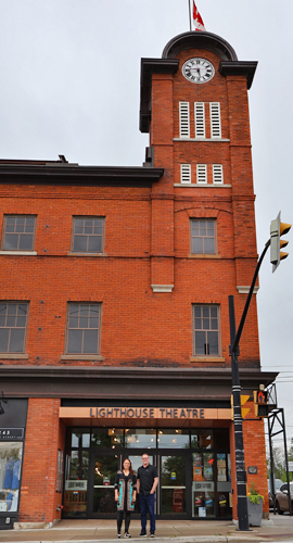 Derek Ritschel and Jane Spence standing in front of Lighthouse Theatre on Main Street.